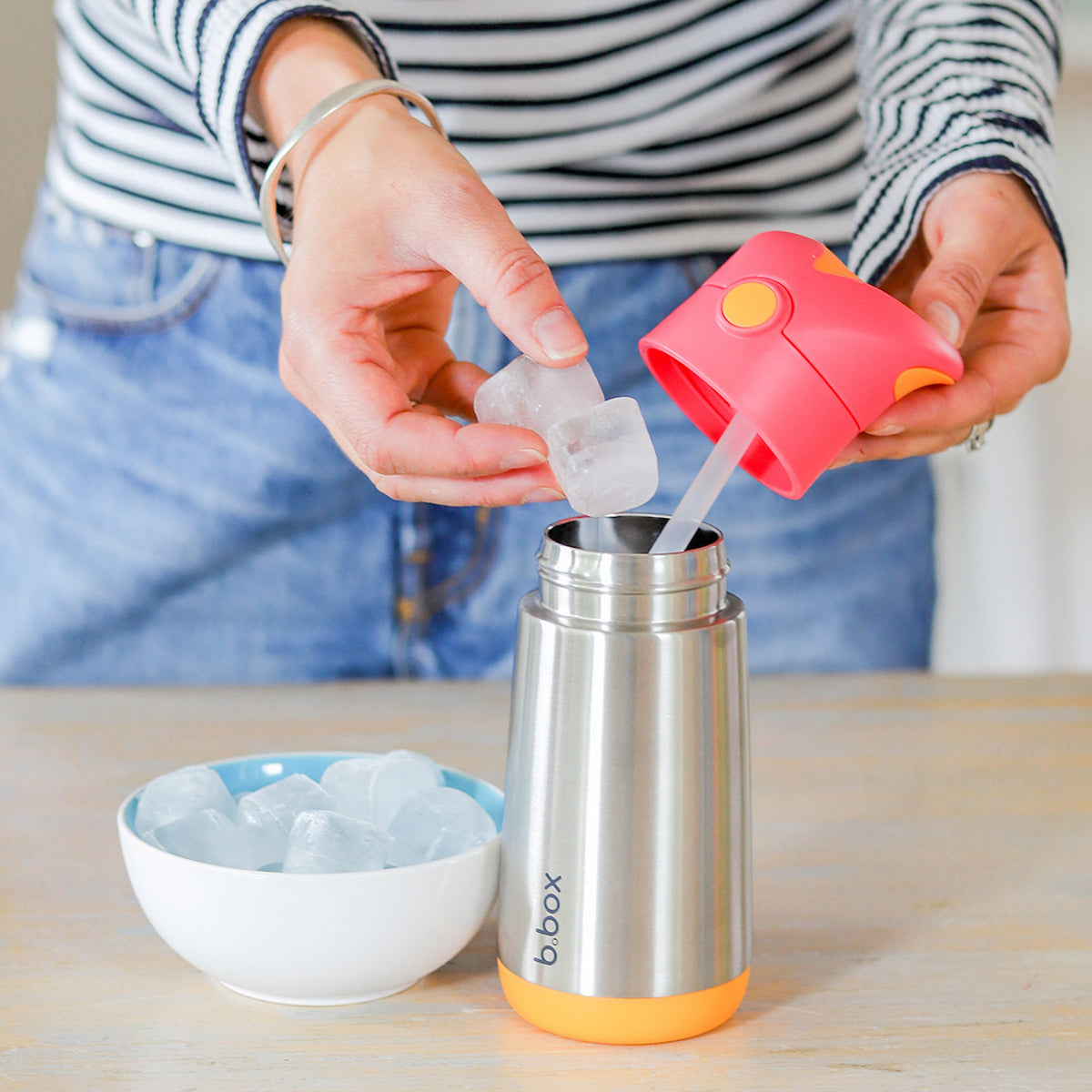 Woman putting ice into the 12 oz insulated water bottle.
