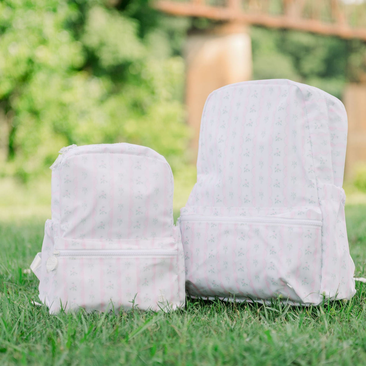 TRVL Mini Backpacker and The Bakerpacker in the Ribbon Floral Pink Print.
