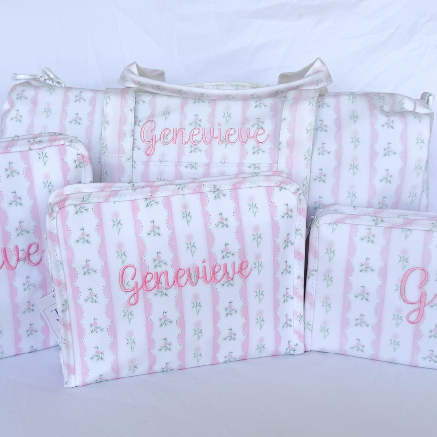 TRVL Weekender Duffle Bag with 'Genevieve' embroidered in a light pink scripty font, with the TRVL large roadie, medium roadie and small roadie also with embroiderey all in the Ribbon Floral Pink print.