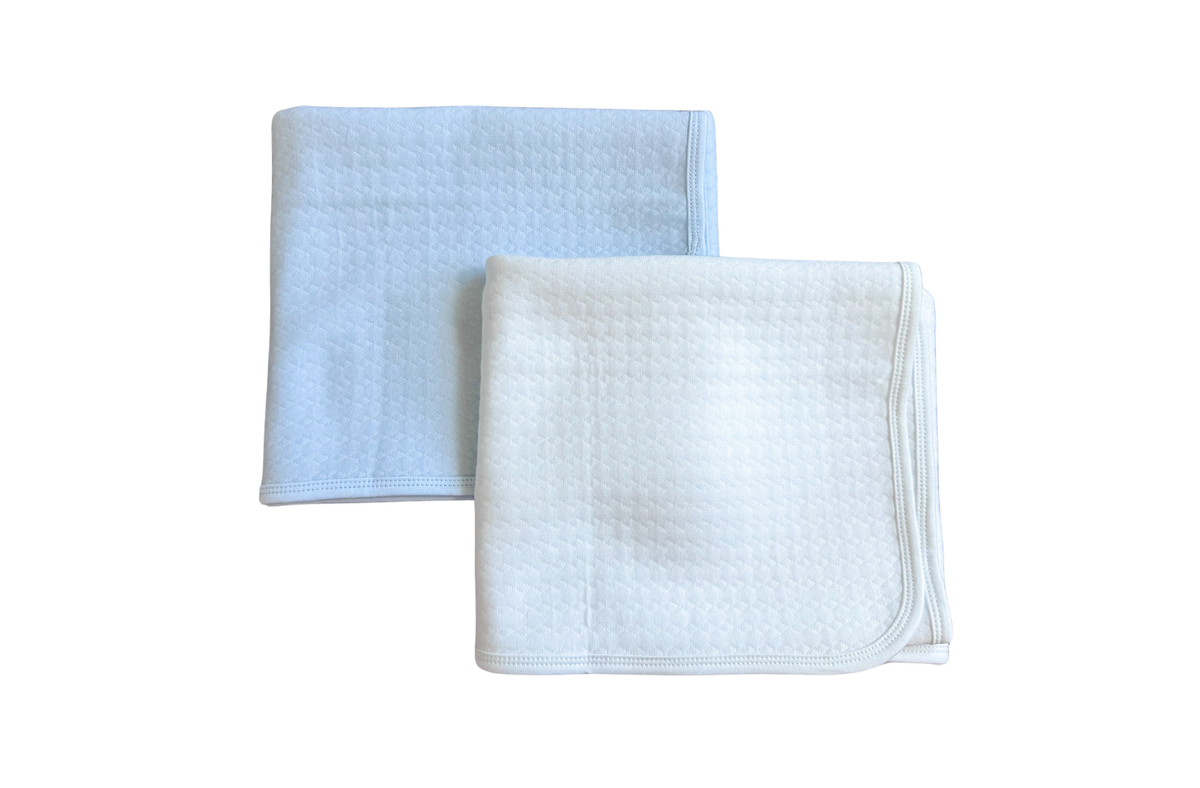 Olivia Quilted Receiving Blanket folded on top of each other in blue and white.