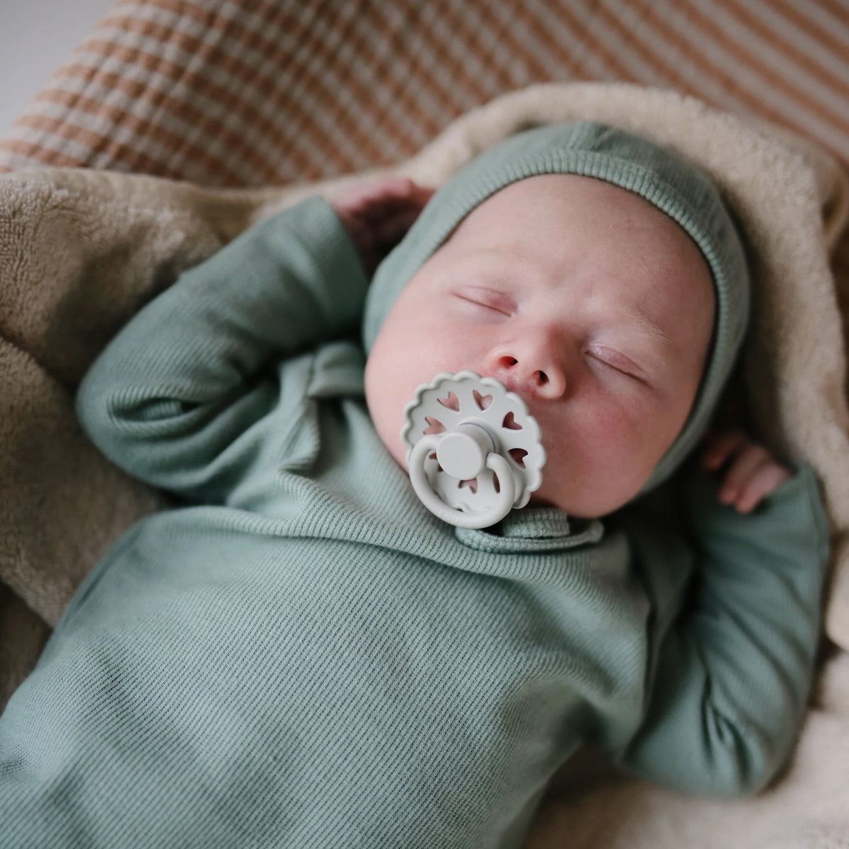 Baby sleeping with the Frigg Fairytale Pacifier in their mouth.